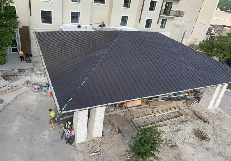 Metal roofing installation team working on a commercial building in Montgomery
